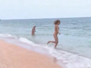 3 nudists играя на на плаж